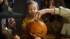 Mother, her toddler and daughter making pumpkin lantern during Halloween celebration at home. Fun craft and decoration at home. Happy children and their mom preparing for the holiday, decorating the h - Powered by Shutterstock - Get 15% off with code: PIKWIZARD15