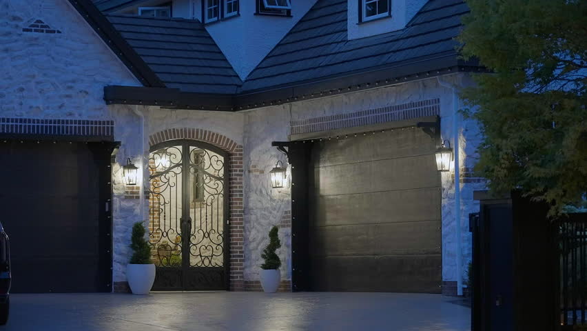 Establishing shot of two story stucco luxury house with garage door, big tree and nice landscape at night in Vancouver, Canada, North America. Night time on June 2024. ProRes 422 HQ.