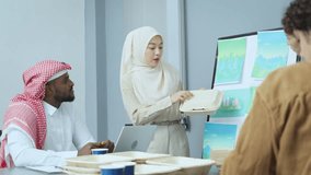 Multicultural business team reviews sustainable packaging solutions, incorporating recycled materials, in an office setting. - Powered by Shutterstock - Get 15% off with code: PIKWIZARD15