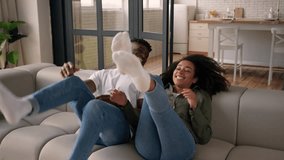African American happy love couple man woman girl guy fall jump on couch rest casual weekend home relocation moving day own house ethnic family smile homeowner tenant relax cuddle on cozy comfort sofa - Powered by Shutterstock - Get 15% off with code: PIKWIZARD15
