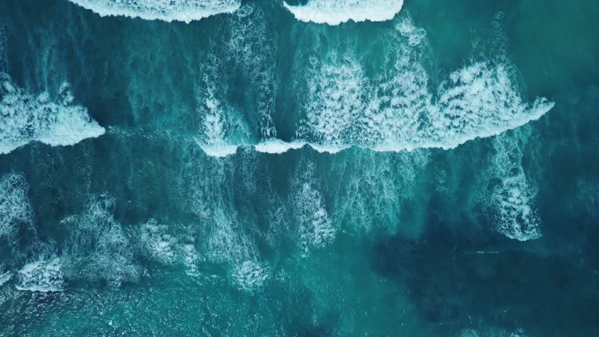Beautiful texture of big power dark ocean waves with white wash. Aerial top view footage of fabulous sea tide on a stormy day. Drone filming breaking surf with foam in Caribbean Sea