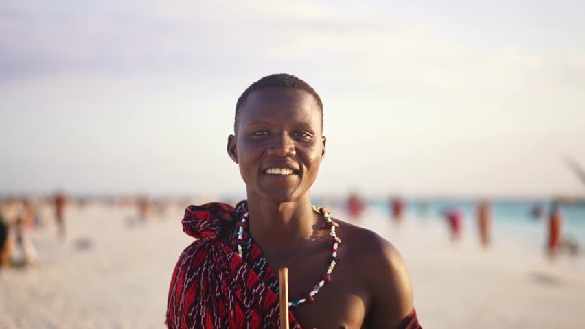 Portrait of African young men Maasai in traditional outfit on beach, warrior tribesman. Zanzibar tropical island vacation in Tanzania. Africa tourism destination. 