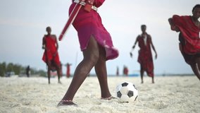 Maasai men in traditional outfit, young men friends play beach soccer. Football in Africa,  Zanzibar tropical island in Tanzania.    - Powered by Shutterstock - Get 15% off with code: PIKWIZARD15