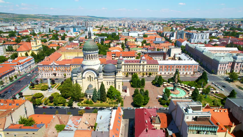 Aerial drone view of The Orthodox Cathedral located on the Avram Iancu Square in the centre of Cluj Napoca, Romania. Cityscape, central square, old buildings, cars