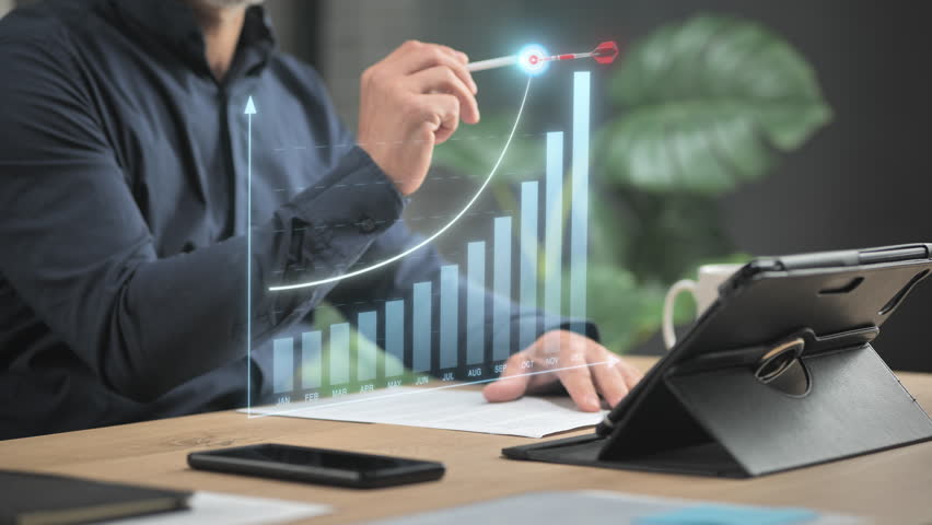 business man at the desk draws growing profit graphic chart on virtual screen reaching target,business growth goal achievement