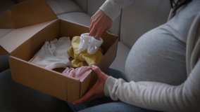 Woman pregnant unrecognizable female girl mother unpacking parcel box delivery service post unpack child cloth kid tiny little shoes put on big belly tummy anticipation child medicine shopping concept - Powered by Shutterstock - Get 15% off with code: PIKWIZARD15