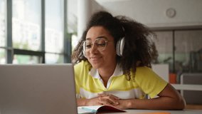 African American student girl female woman freelancer working studying laptop video call write task note talking distant virtual computer conference wearing headphones education e-learning university - Powered by Shutterstock - Get 15% off with code: PIKWIZARD15