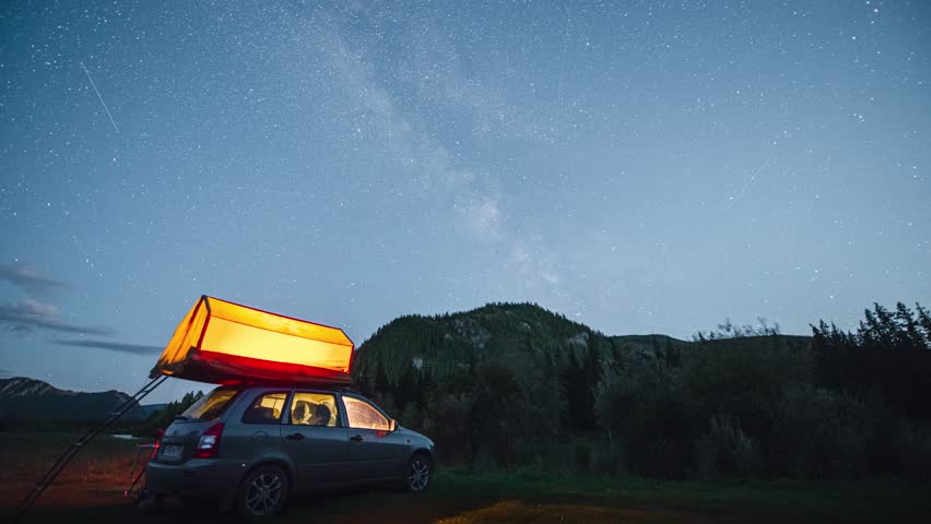 timelapse of the starry sky over a motorhome in the mountains