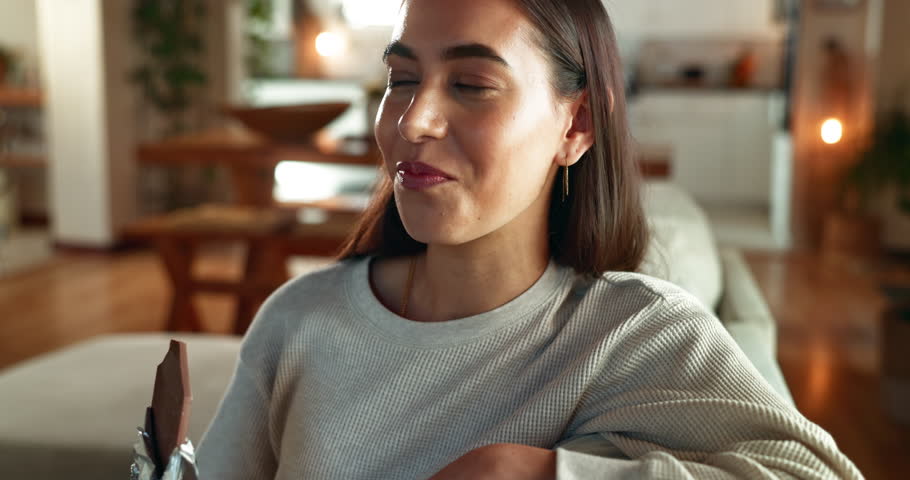 Home, chocolate bar and woman on sofa, eating and thinking with break, relax and comfort food. Happy person, apartment and girl on couch, calm and sweet snack with candy treat, nutrition and cacao