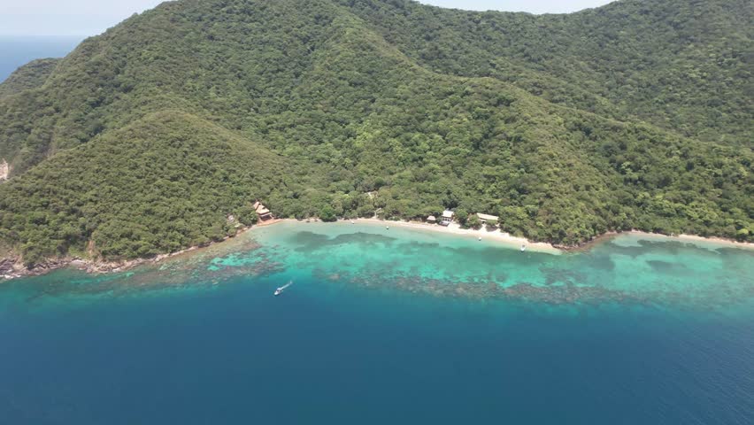 Aerial view of Cinto Bay with turquoise waters and lush forest in Tayrona National Park, Colombia