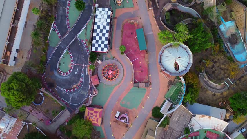 Aerial view of abandoned amusement park Tivoli World located in Benalmadena, Spain. Many different attractions, green park, no people. Drone view.
