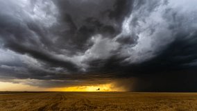 A tranquil scene unfolds as a wind farm stands tall against the backdrop of a setting sun, casting a warm glow over peaceful wheat fields. - Powered by Shutterstock - Get 15% off with code: PIKWIZARD15