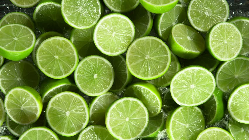 Super Slow Motion Shot of Splashing Fresh Limes . Filmed on High Speed Cinematic Camera at 1000fps .