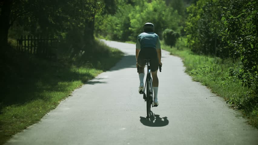 Triathlete Cyclist Training On Bicycle. Fit Athlete Workout Training Cycling For Triathlon Competition. Sport 
Exercing. Cyclist Fitness Riding On Road Bike Getting Ready For Triathlon. Hard Workout