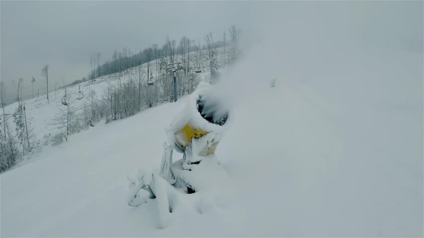 Making technical snow with a snow cannon, preparing winter season in alpine ski resort