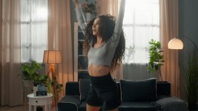 Active fit Hispanic Arabian ethnic woman female athletic sportswoman fitness girl in sportswear jumping exercise jump raising hands cardio training sport weight loss pilates workout inside home room - Powered by Shutterstock - Get 15% off with code: PIKWIZARD15