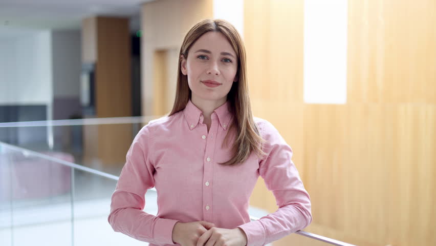 Video portrait of a beautiful businesswoman standing in a hallway of her company