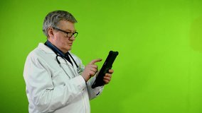 Senior doctor touching, clicking on tablet screen and smiling, using digital device on his work. - Powered by Shutterstock - Get 15% off with code: PIKWIZARD15