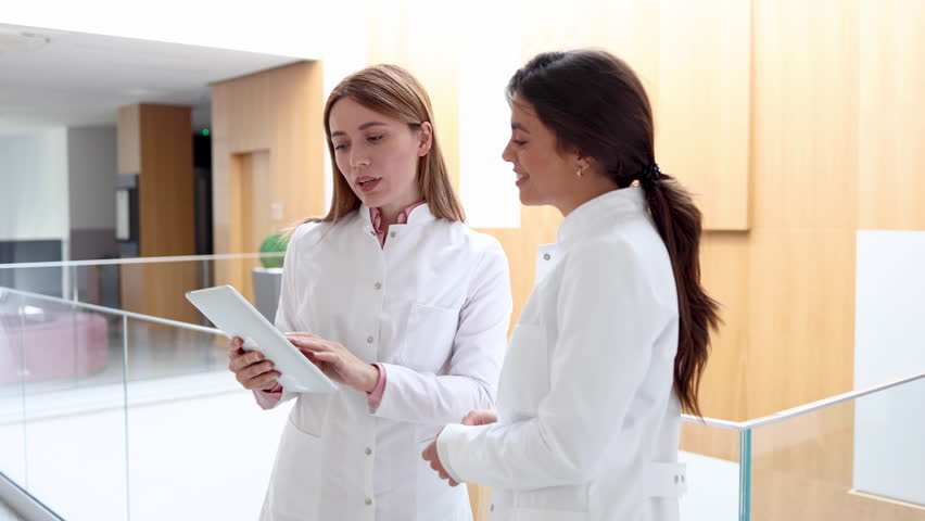 Two female scientists discussing some research at the hallway of the hospital