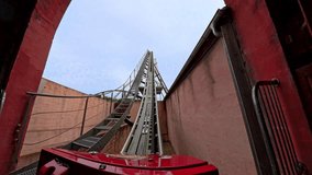 First-person perspective of a red roller coaster climbing the lift hill, capturing the anticipation and upward motion before the thrill of the ride - Powered by Shutterstock - Get 15% off with code: PIKWIZARD15