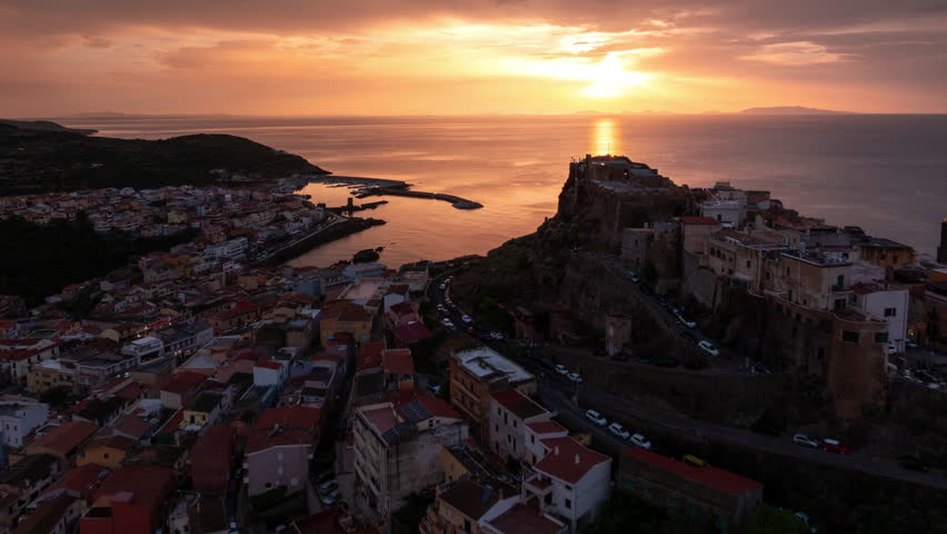Scenic sunset over Castelsardo village in Sardinia, Italy, aerial hyperlapse view with moving clouds in the sky