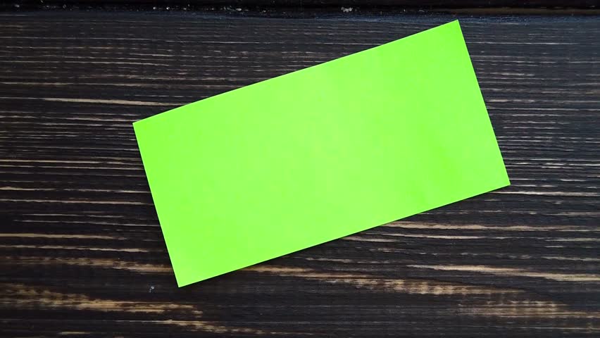 A man writes thank you on a sticker on a dark table background. Slow motion
