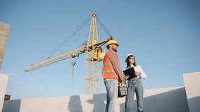 Construction workers discuss project plans at a busy construction site under clear blue skies - Powered by Shutterstock - Get 15% off with code: PIKWIZARD15