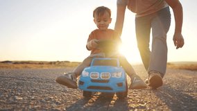 Father teaches his son how to drive a car. Family boy together concept. Father and child play with a toy car on the asphalt. Father takes his son for a ride in a toy car on the asphalt lifestyle -. - Powered by Shutterstock - Get 15% off with code: PIKWIZARD15