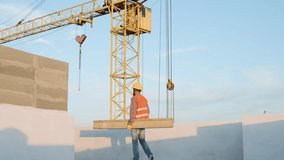 Construction workers lift beams at a construction site during sunset - Powered by Shutterstock - Get 15% off with code: PIKWIZARD15