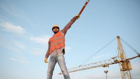 Construction site worker directing traffic at a busy development area in the early evening sunlight - Powered by Shutterstock - Get 15% off with code: PIKWIZARD15