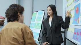 Businesswoman in a suit presenting data charts and graphs on a board during a meeting, engaging with her colleague. - Powered by Shutterstock - Get 15% off with code: PIKWIZARD15