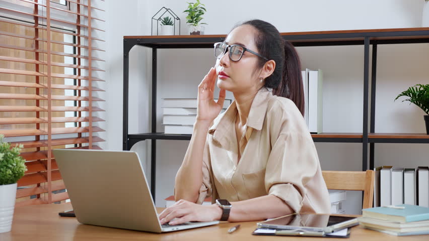 Young asian business woman working with laptop while thinking for planning financial on desk in modern home office, businesswoman planning and thoughtful about working, business and finance.