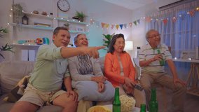 Group of Asian senior friend having evening party in living room at home. Mature elderly man and woman having fun, enjoy spend free leisure time celebrate weekend reunion gathered together in house. - Powered by Shutterstock - Get 15% off with code: PIKWIZARD15