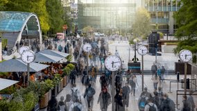 Timelapse view of motion blurred business people rushing from work with analogue clocks in front at the financial centre Canary Wharf - Powered by Shutterstock - Get 15% off with code: PIKWIZARD15