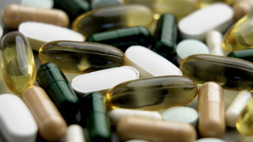 Assortment of dietary supplements consisting of different pills and capsules. Macro shot. Rotation