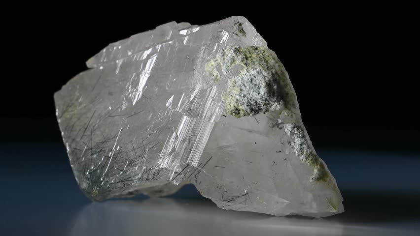 Rutilated Quartz (quartz containing needle-like inclusions of rutile) sample rotating against a black background