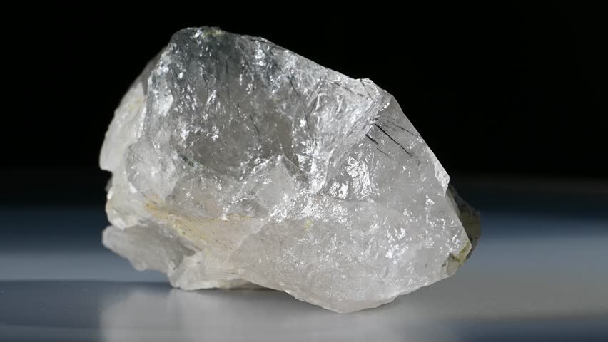 Rutilated Quartz (quartz containing needle-like inclusions of rutile) sample rotating against a black background