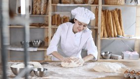 Girl works in bakery, kneads dough, works with flour. Working moment, process of creating croissants in bakery. She hardly knead tight dough, combine flour, water and other ingredients to make dough - Powered by Shutterstock - Get 15% off with code: PIKWIZARD15