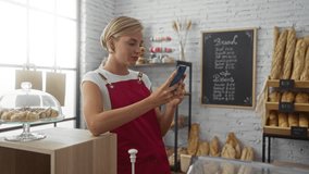 Woman using smartphone at bakery counter with bread and pastries in background - Powered by Shutterstock - Get 15% off with code: PIKWIZARD15