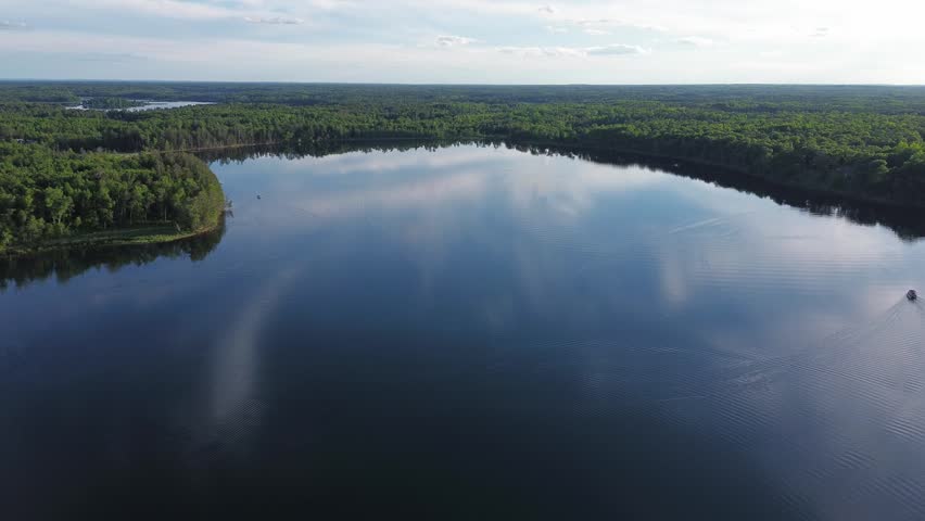 Drone shot over large lake in Northern Wisconsin surrounded by trees