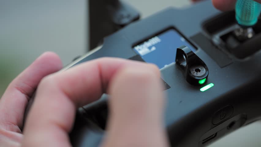 FPV drone pilot, close-up, hands holding the remote control.