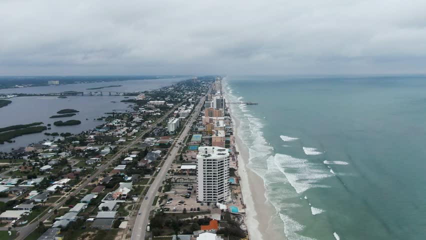 Wide aerial view of city, ocean, and river at Daytona Beach, Florida on an overcast day