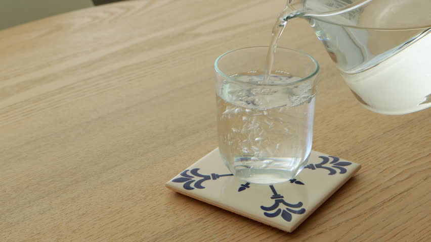 Clean drinking water filling glass on table in kitchen aesthetic