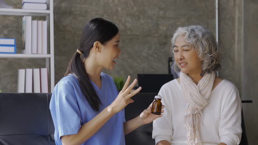 Young nurse explains the correct dosage of medicine to a senior patient, ensuring understanding and promoting health