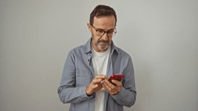 Hispanic man, middle age, shocked expression covering mouth with hand while looking at smartphone, isolated over white background, surprised and afraid - Powered by Shutterstock - Get 15% off with code: PIKWIZARD15