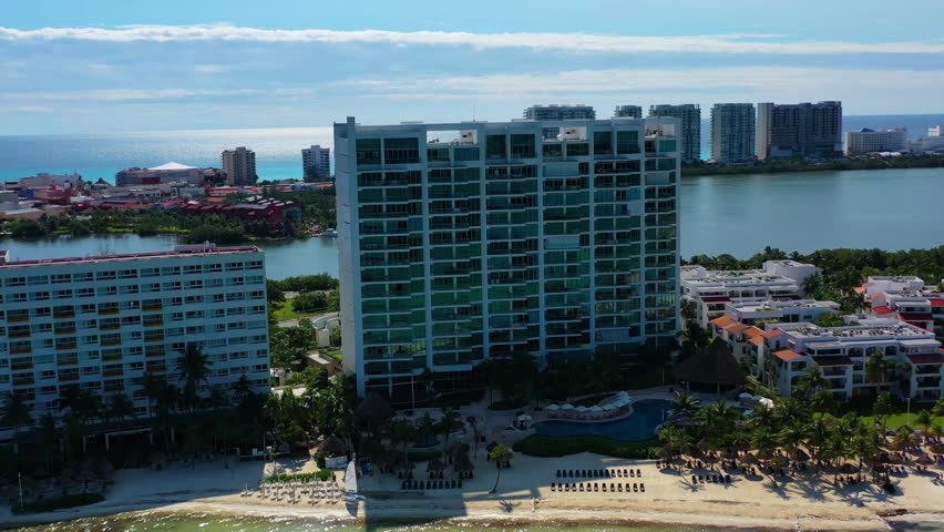 Aerial view of the stunning beaches and shoreline in Cancun, Mexico, showcasing crystal-clear turquoise waters, white sandy beaches, and vibrant coastal scenery under the tropical sun.