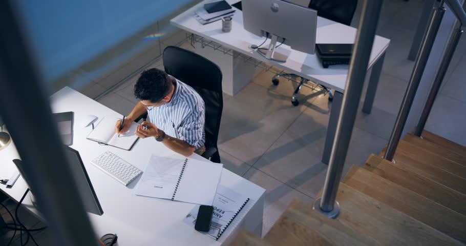 Computer, business man or writing in notebook for research and online report at night. Top view, desktop or worker with notes in startup for movie script review or creative screenwriter on deadline