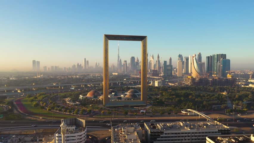 The Dubai Frame is a famous landmark in Dubai, featuring a massive rectangular structure with a glass bridge at the top.