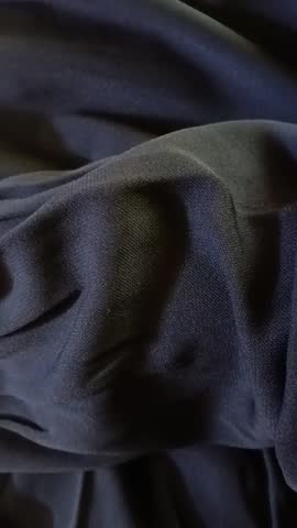 The arms of a woman wearing long-sleeved clothing with lace at the fingertips, wearing jewelry in the form of carved gold bracelets.