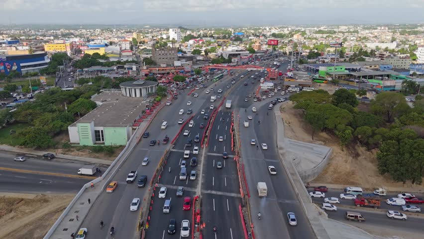 Santo Domingo , Dominican Republic - 08 14 2024: Aerial Birds Eye shot of Traffic in City of Santo Domingo at sunset time. Busy rush hour time on Dominican Republic. Establishing shot.